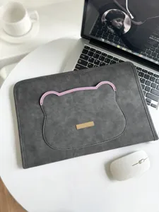 Detailansicht der grauen Laptoptasche mit süßem Bärenohren-Design auf minimalem weißem Schreibtisch.
