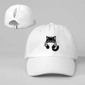 Vista detallada de gorra de béisbol blanca con bonito estampado de gato negro y correa.