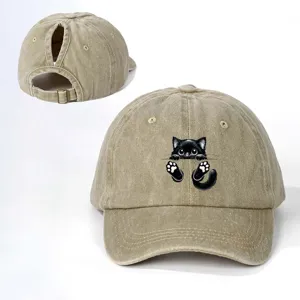 Vista detallada de la gorra de béisbol caqui con estampado de gato negro y correa ajustable.