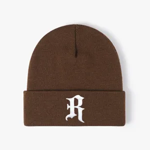 Brown knit beanie hat detail view, white embroidered R letter logo, winter warm headwear