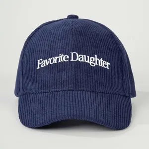 Close-up detail of the navy blue corduroy baseball cap with white embroidered text.