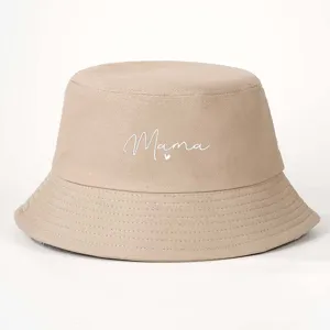 Beige bucket hat featuring a stylish Mama embroidery script, perfect for casual outdoor wear.