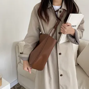 Detail view of retro minimalist brown leather shoulder bag, versatile fashion underarm tote.