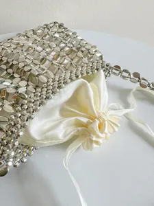 Silver metallic beaded woven handbag with satin drawstring inner pouch for women fashion.
