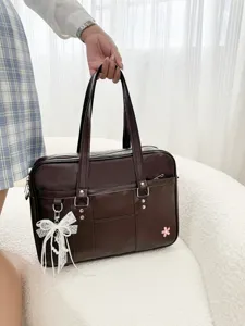 Dark brown JK uniform bag detail showing leather texture, lace bow and pink flower accent.