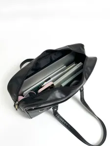 Detailed view of large capacity black PU leather JK uniform bag with organized interior.