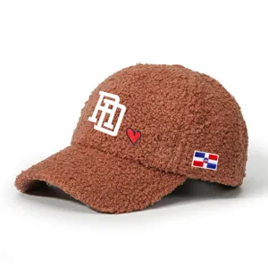 Brown shearling baseball cap with embroidered RD letter heart and flag detail for outdoor wearing.