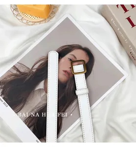 Minimalist white thin belt with square gold buckle, chic women fashion accessory detail view.