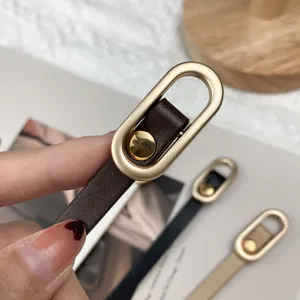 Minimalistische smal leren riem met een ovale metalen gesp voor jurken en blouses.