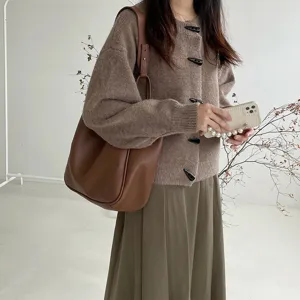 Detail shot of retro brown leather shoulder tote bag, stylish daily outfit scene display.