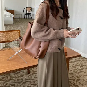 Minimalist brown leather tote bag detail, vintage large capacity shoulder bag lifestyle view.