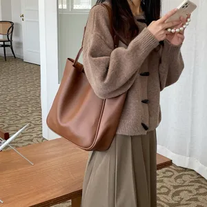 Stylish brown leather tote bag for women, minimalist large capacity shoulder bag daily use.