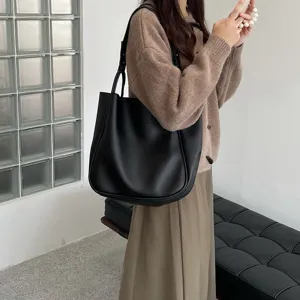 Minimalist black leather shoulder bag, large capacity daily tote for women, elegant style detail.