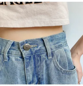 High waist denim jeans waist detail close-up showing metal button and classic blue wash.