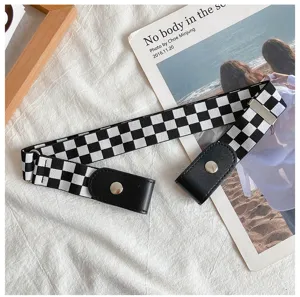 Detail shot of black and white checkerboard elastic belt with leather buckle and snaps.