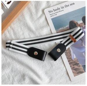 Detail view of a black and white striped elastic buckle free lazy belt with black leather tabs.