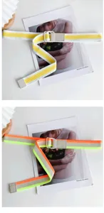 Gros plan détaillé d'une ceinture en toile élégante aux couleurs contrastées avec boucle métallique.