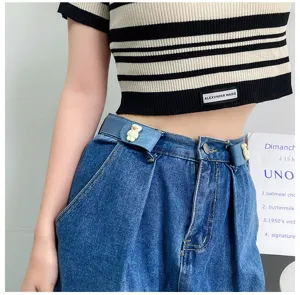 Close-up detail of the elastic invisible waist belt with cute bear decor on denim jeans.