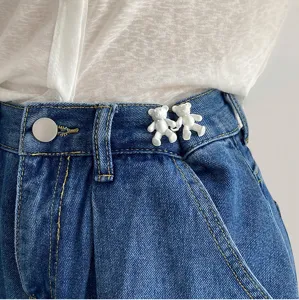 Gros plan détaillé du clip de serrage de taille ours blanc mignon sur jean bleu, pratique.