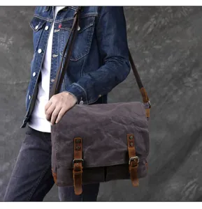 Vintage canvas messenger bag with brown leather straps and retro hardware detail.