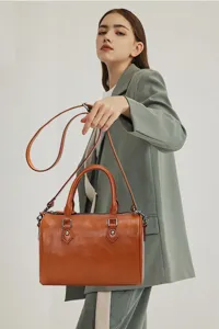 Vintage genuine leather Boston shoulder bag for women, classic brown barrel handbag.