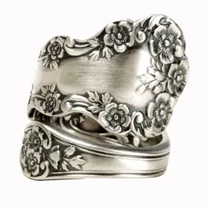 Primer plano de anillo de cuchara de plata vintage con patrones florales y acabado oscuro.