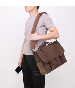 Close-up detail view of the vintage waxed canvas shoulder messenger bag worn by male model.