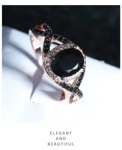 Primo piano di un anello in oro rosa con pietra nera ovale e alone di zirconi scintillanti.