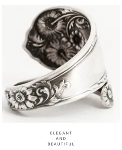 Close-up of vintage daisy spoon ring featuring intricate floral carvings and adjustable band.