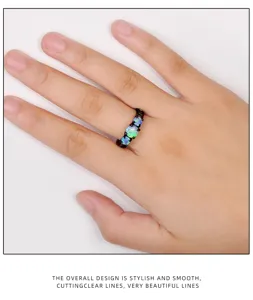 Vue détaillée de la bague en or noir ornée de trois opales bleues vibrantes, superbe.