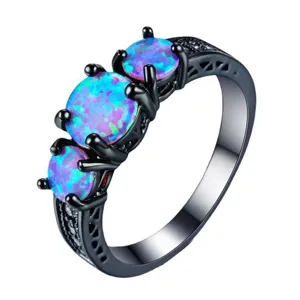 Superbe bague trois pierres en opale bleue avec anneau en or noir pour les femmes.