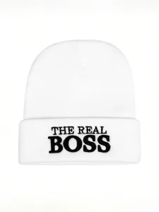 Detailed close-up of the embroidered text on the white knitted beanie cuff, winter.
