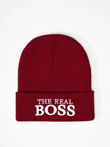Burgundy knit beanie detail showcasing white embroidered lettering on the folded cuff.