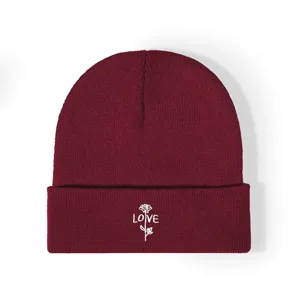 Gros plan détaillé sur le bonnet d'hiver en tricot chaud avec de délicates broderies de roses.