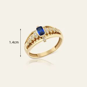 Elegante anello placcato oro con uno zaffiro blu rettangolare e zirconi cubici scintillanti.