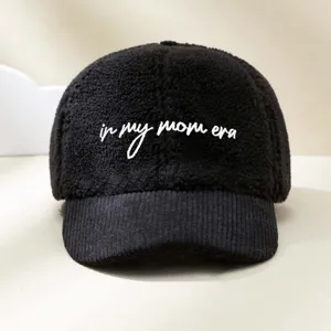 Nahaufnahme der schwarzen Fleece- und Cord-Baseballcap mit besticktem Slogan-Design.