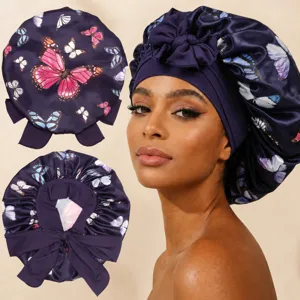 Close-up of satin hair bonnet with vibrant butterfly print and adjustable tie band detail.