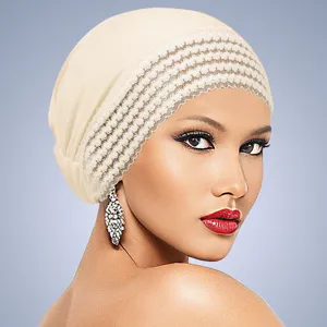 Nahaufnahme der beigen Beanie-Mütze mit Spitzendetail zeigt feine Textur und elegantes Design.