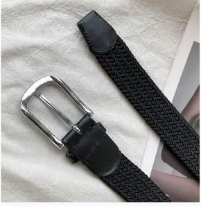 Detail view of black woven elastic belt with silver metal pin buckle for casual daily wear.