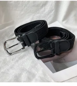 Detailed view of black woven elastic belts with metal pin buckles, casual stretch design.