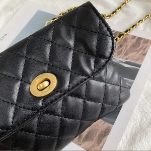 Black quilted leather mini bag with gold chain strap and turn-lock closure fashion accessory.