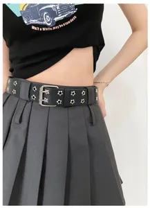 Close-up of black punk style double grommet belt with star studs for women fashion outfit.