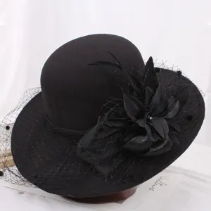 Detailed view of black wool felt Hepburn hat, featuring elegant mesh veil, feathers and floral decor.