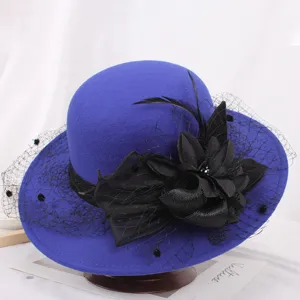 Detailed shot of elegant blue wool bucket hat with black mesh fabric flower and feather decor.