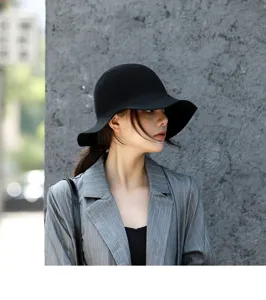 Close-up detail of women's black wool felt bucket hat with wavy wide brim, elegant and chic style.