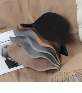 Detailed view of stacked woolen bucket hats in various colors, showcasing winter fashion style.