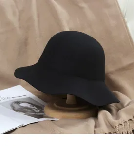 Detailed closeup view of the black wool felt bucket hat featuring a stylish wavy wide brim.