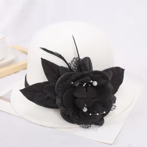 Détail du chapeau en feutre de laine blanc avec fleur en tissu noir, résille et perles style rétro.