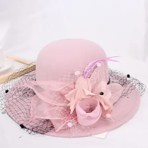 Chic pink wool felt bucket hat for women with elegant mesh, floral and feather decoration.