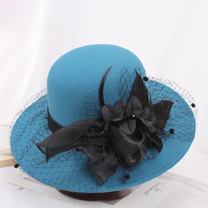 Elegant blue felt cloche hat featuring black mesh veil and floral decor for winter.